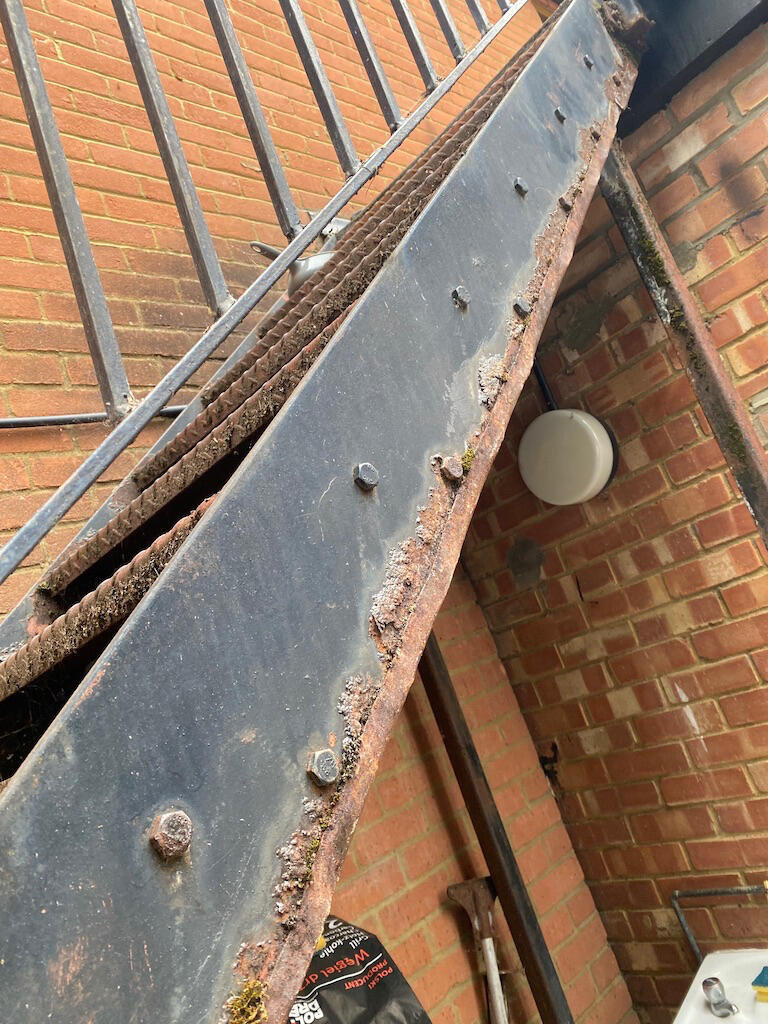 Rusty fire exit metal stairs before painting showing corrosion and worn surfaces