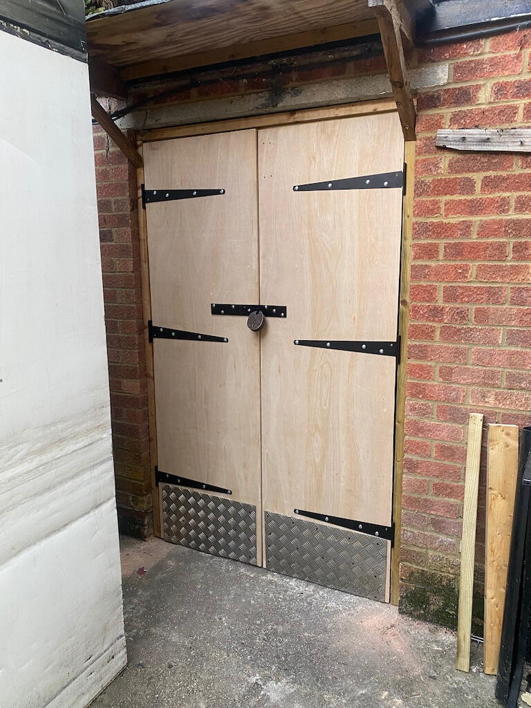 Finished wooden outdoor storeroom doors with new hinges and locks professionally fitted